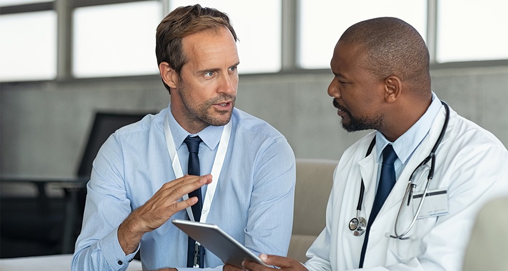 A doctor and a consultant have a conversation in an office