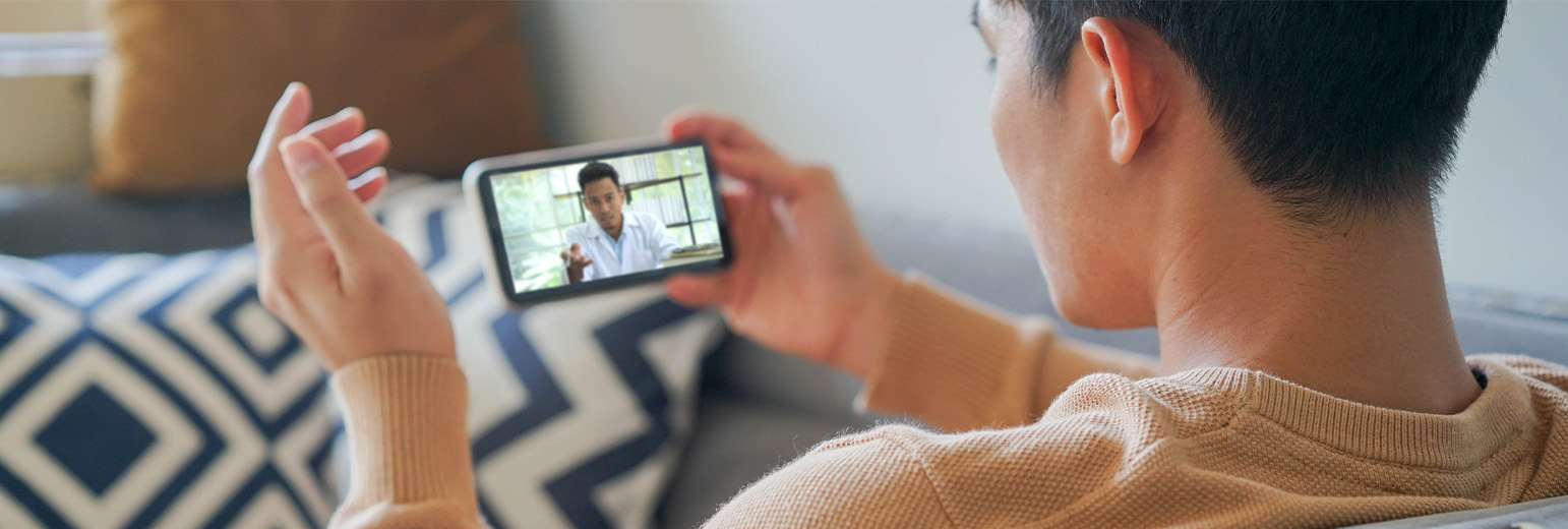 A young man video calling a doctor on a smartphone