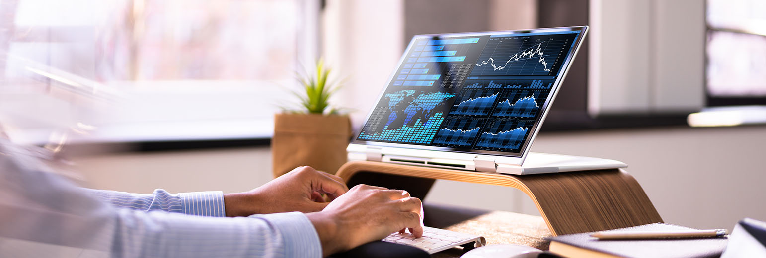 A professional looking at graphs on a monitor.