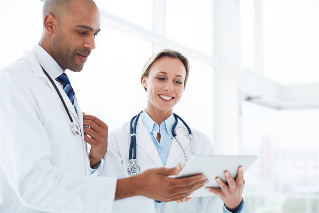 A pair of doctors review data on a tablet