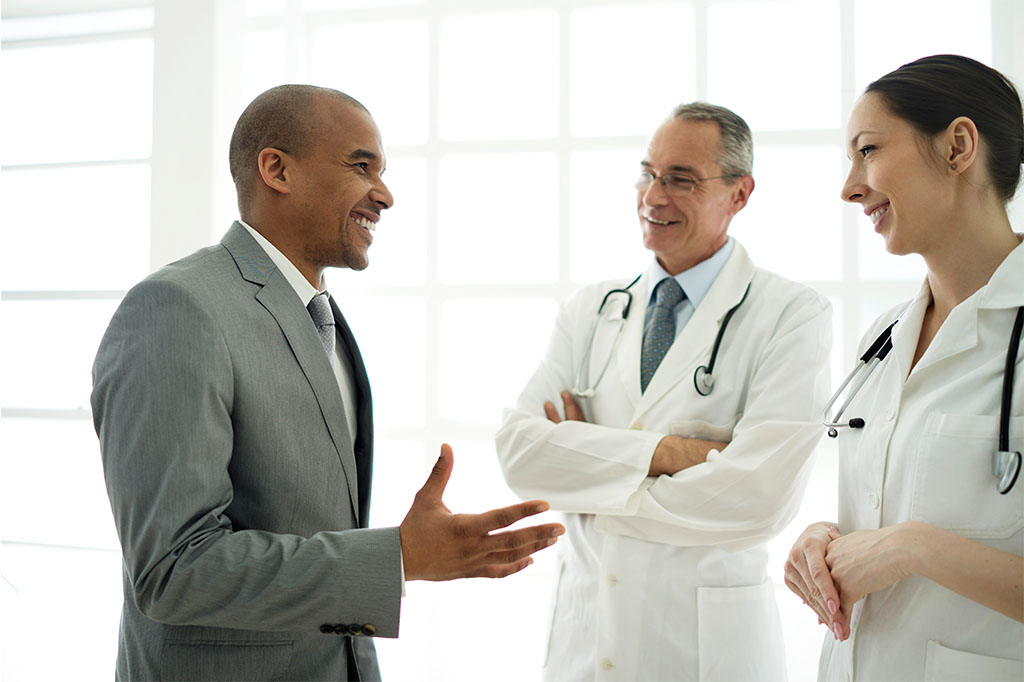An administrator speaks with two doctors