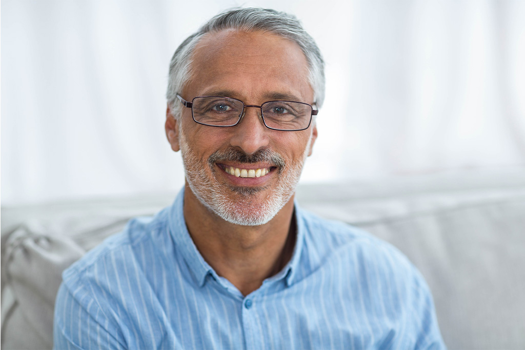 A middle aged man with glasses smiles at the camera