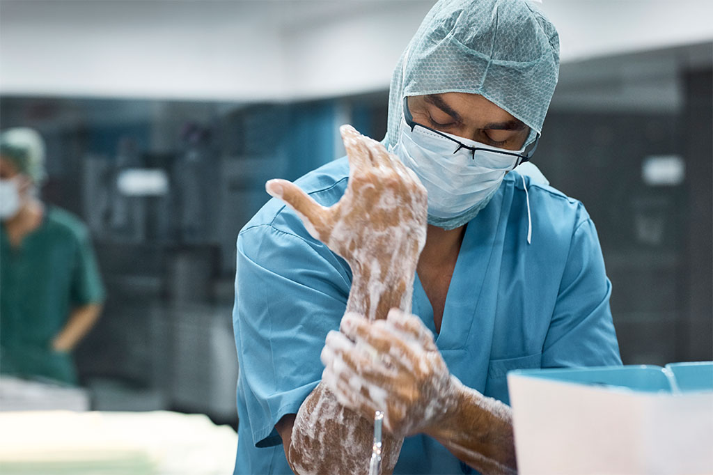 A surgeon washes their hands before entering the operating room