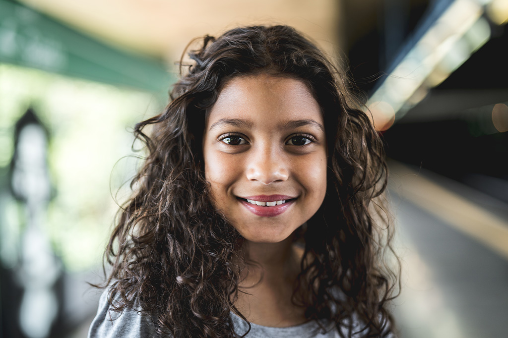 A smiling young girl with curly hair