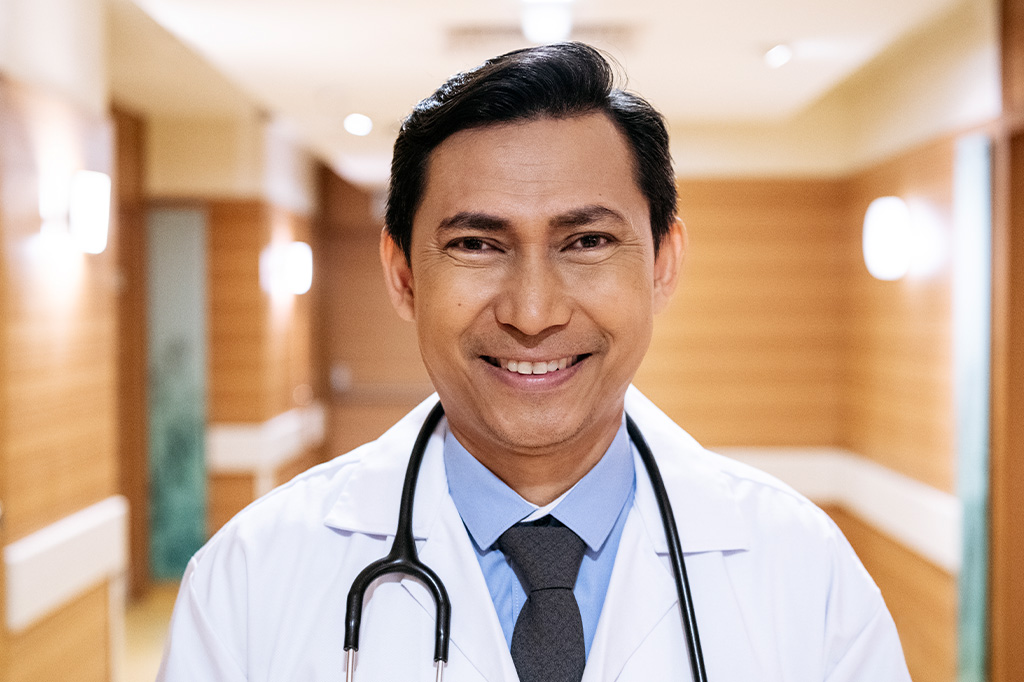 A smiling doctor in a hospital hallway